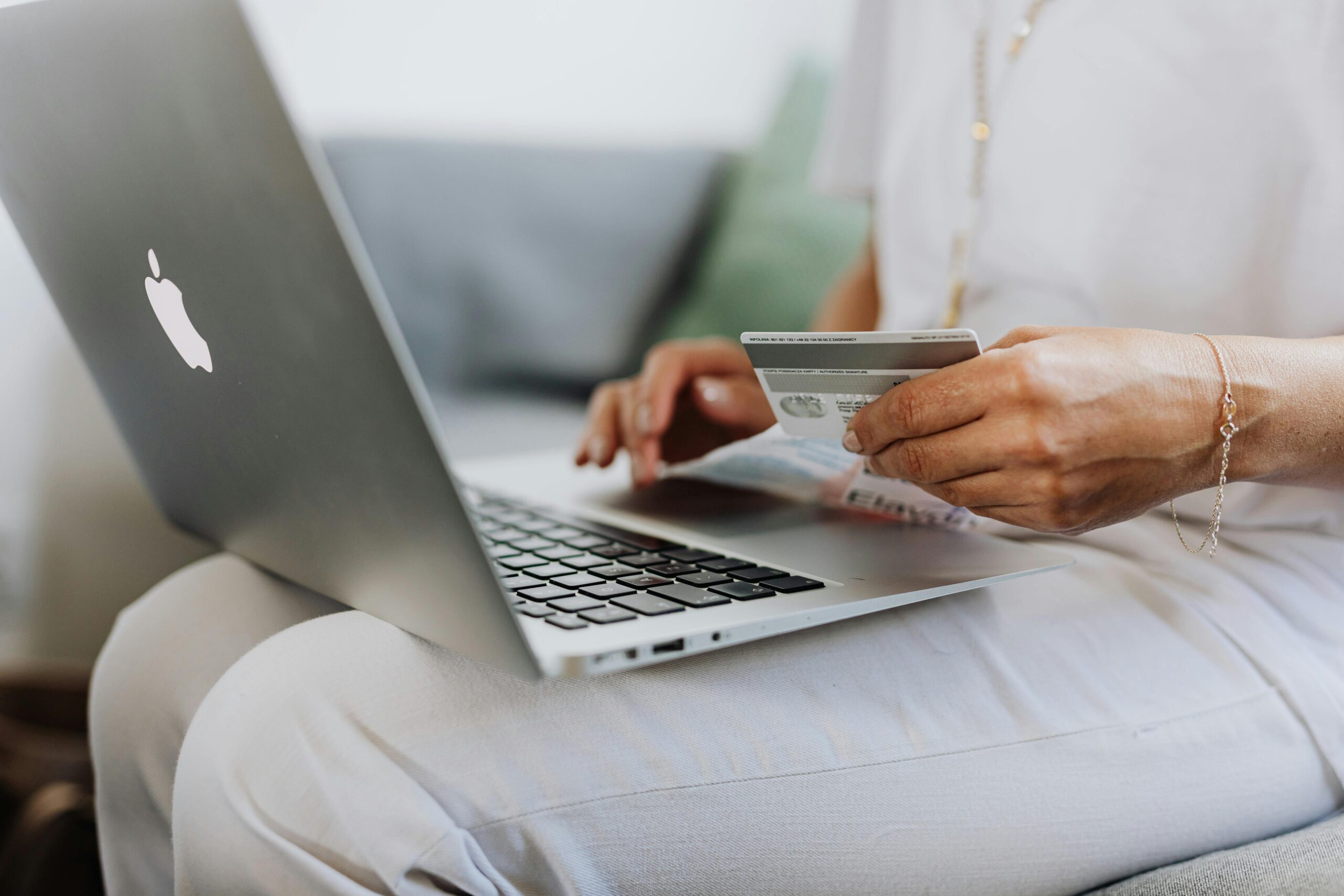 A woman on her laptop, paying for a purchase via credit card.