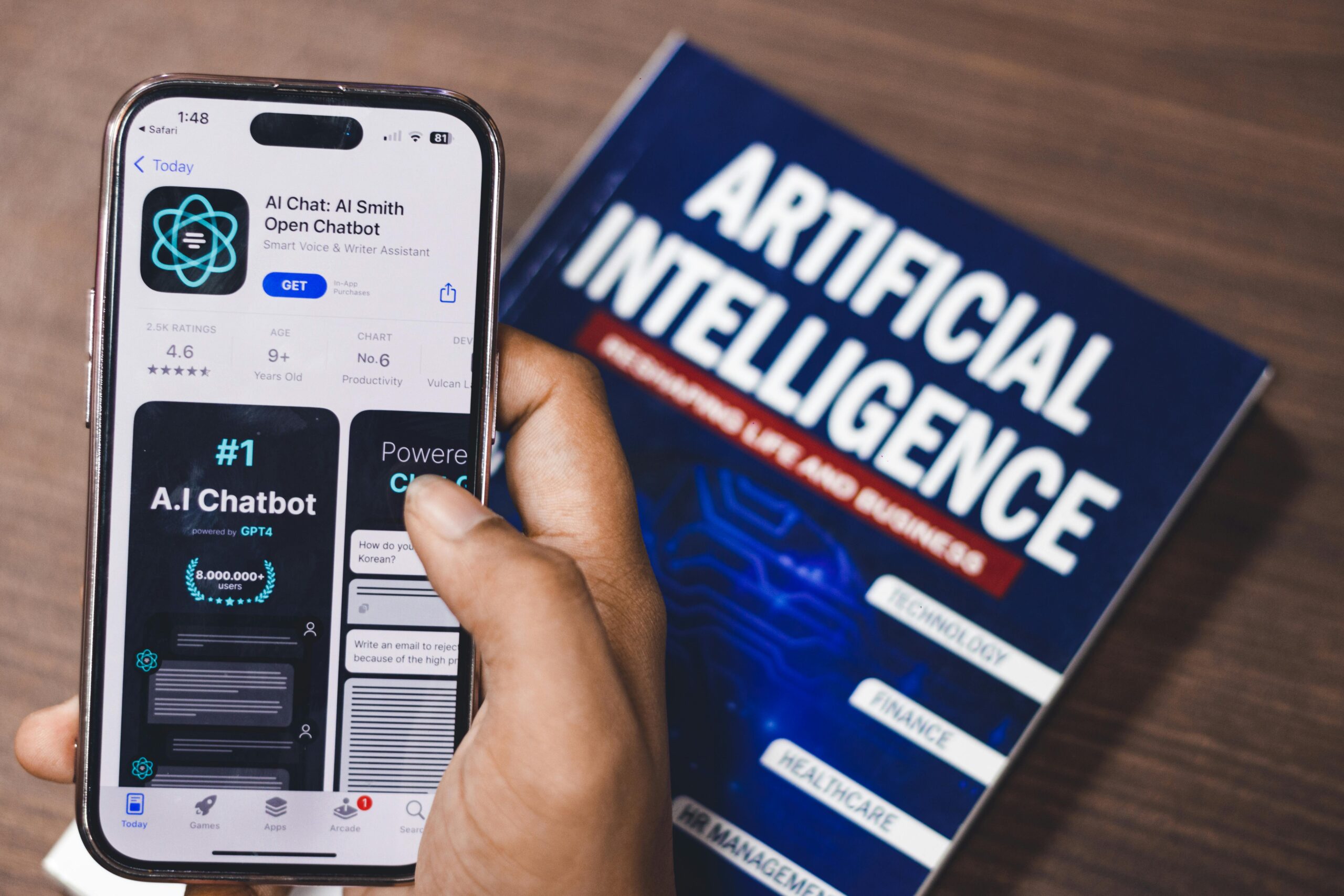 A phone showing an AI chatbot app with an AI book in the background.